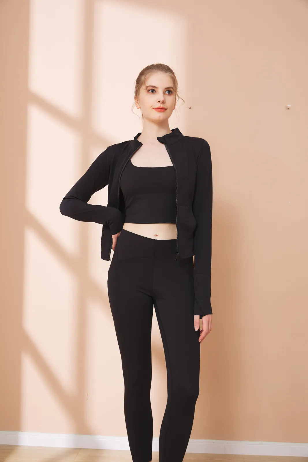 Model in a black seamless zip-up jacket and leggings