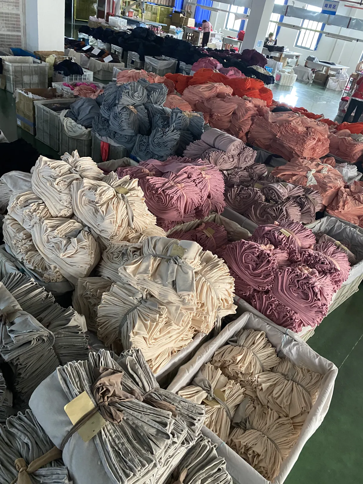 Bundles of cut activewear panels and fabric stock on the production floor
